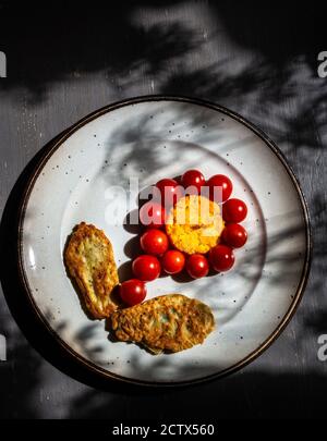 Zucchini Krapfen und ein Butternut backen mit kleinen Tomaten in Form einer Blume. Stockfoto