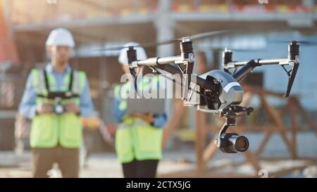 Zwei Spezialisten nutzen Drone auf der Baustelle. Architekturingenieur und Sicherheitsingenieur fliegen Drohne auf der Baustelle Stockfoto