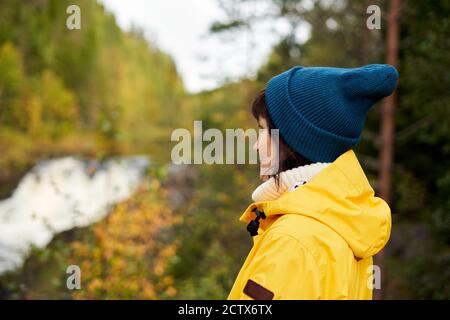 Eins mit der Natur. Rückansicht der unkenntlich Frau Blick auf Wald und Wasserfall Stockfoto