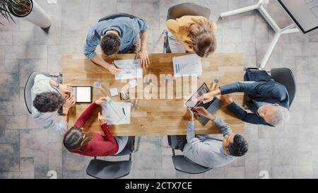 Startup Meeting Room: Team von Unternehmern sitzen am Konferenztisch haben Diskussionen, Probleme lösen, verwenden Sie Digital Tablet, Laptop, Teilen Stockfoto