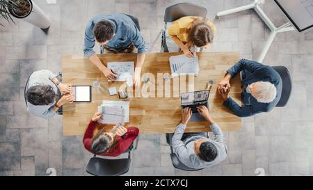 Startup Meeting Room: Team von Unternehmern sitzen am Konferenztisch haben Diskussionen, Probleme lösen, verwenden Sie Digital Tablet, Laptop, Teilen Stockfoto