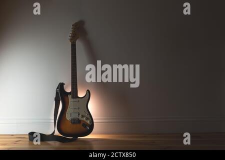 Musik Sound Hintergrund mit klassischer Elektro-Gitarre und schwarzem Kabel Auf Wandhintergrund Stockfoto