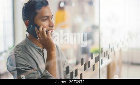 Portrait of Handsome Professional Indian man nutzt Handy, spricht mit Kunden und schließt Business Deals. Erfolgreicher Mann Mit Smartphone Arbeiten Stockfoto