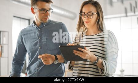 Junge Frauen und Männer Kollegen stehen im Büro und haben freundliche Diskussion über neue Geschäftsideen. Lockere Coworking Atmosphäre Stockfoto