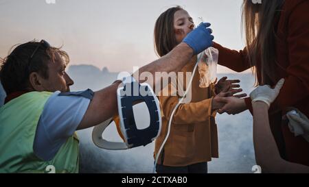 Ein Team von Sanitätern führt Nothilfe für verletzte Mutter und junge Tochter durch. Sauerstoffmaske geben und auf Verletzungen prüfen. Autocrash Verkehr Stockfoto