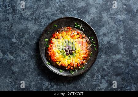 Rainbow Veggie Paprika Pizza Kruste auf Teller über blauen Stein Hintergrund mit freien Text Raum. Vegetarisch vegan oder gesundes Lebensmittelkonzept. Draufsicht, Stockfoto