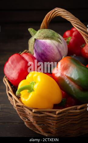 Frische Herbsternte von Bio-Gemüse, Paprika mit Tomaten, Auberginen und Kürbis, Gemüse in einem Weidenkorb Stockfoto