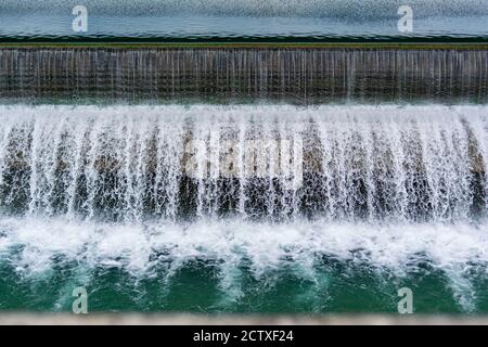 Blick von oben auf den vorbeirauschenden Wasserfluss Der Staudamm Stockfoto