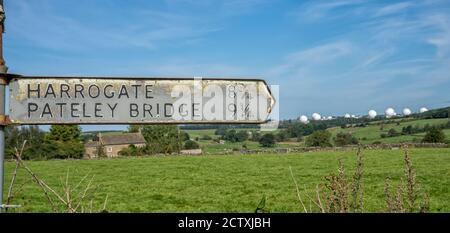 Old Harrogate und Pateley Bridge Wegweiser mit Menwith Hill Golf Balls im Hintergrund, North Yorkshire, England, Großbritannien Stockfoto