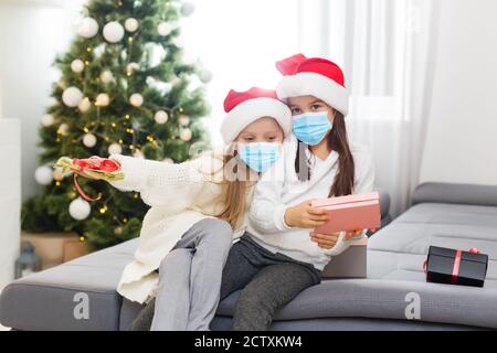 Kinder lernen zu Hause in einer schützenden Gesichtsmaske während Quarantine CoVid-19, Kinder in Schutzmaske zu Hause zu weihnachten Stockfoto