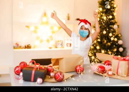 Kinder lernen zu Hause in einer schützenden Gesichtsmaske während Quarantine CoVid-19, Kinder in Schutzmaske zu Hause zu weihnachten Stockfoto