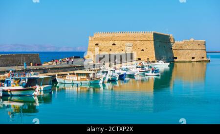 Alte venezianische Festung in Heraklion und Fischerboote in der Nähe, Kreta Insel, Griechenland Stockfoto