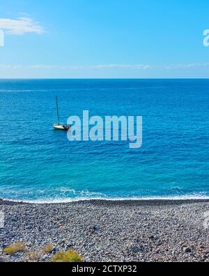 Kleines Segelboot im Atlantischen Ozean vor der Küste Teneriffas, Kanarische Inseln, Spanien. Minimalistisches Meeresumhang Stockfoto