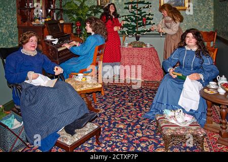 Kleine Frauen Weihnachtsszene, Schaufensterpuppen, Mutter, vier Töchter, Teestunde, Baum dekorieren, Orgel spielen, Lesung, National Christmas Center, Lancas Stockfoto