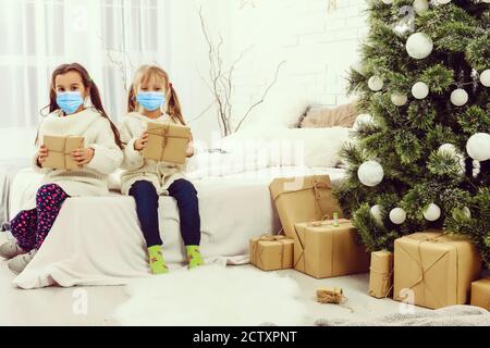 Kinder lernen zu Hause in einer schützenden Gesichtsmaske während Quarantine CoVid-19, Kinder in Schutzmaske zu Hause zu weihnachten Stockfoto