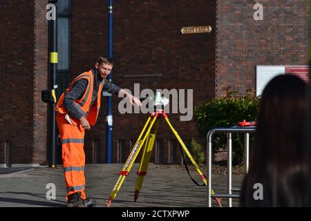 Arbeiter, der Messgeräte in der Nähe des HS2-Standorts im Stadtzentrum von Birmingham, Moor Street Queensway, verwendet Stockfoto