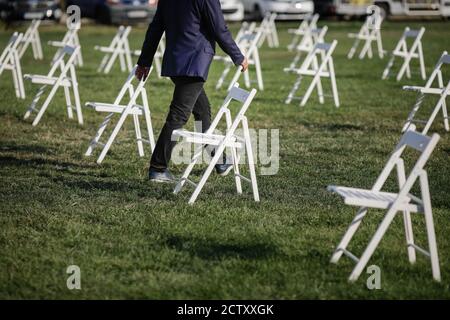 Chairs apart one from another to maintain the social distance during the Covid-19 outbreak at an outdoor event on the grass Stockfoto