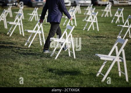 Stühle auseinander, um die soziale Distanz zu halten Während des Covid-19 Ausbruchs bei einem Outdoor-Event auf dem Gras Stockfoto