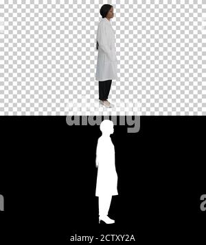 Junge hübsche Doktor schwarze Frau Fixierung ihr Abzeichen, Alpha Channel Stockfoto