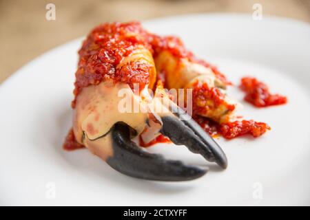 Eine gekochte, rissige Krabbenklaue aus einer braunen Krabbe, Cancer Pagurus, die mit einer Chili- und Knoblauchsoße serviert wurde. Dorset England GB Stockfoto