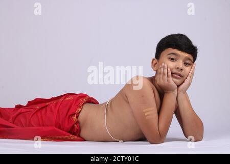 Junge indische Jungen in ethnischen tragen Verlegung oder genießen Freizeit auf weißem Hintergrund. Stockfoto