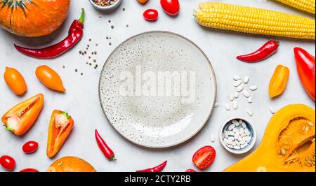 Herbstgemüse und eine Keramikplatte. Langes Banner Stockfoto