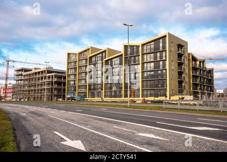 Apartmentkomplex im Bau entlang einer großen städtischen Straße an Sonnenuntergang Stockfoto