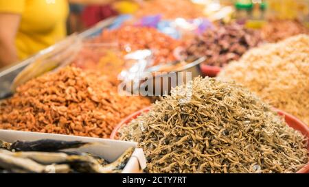 Ein Stallverkäufer, der trockenen Garnelenfisch und verschiedene Zutaten in einem beliebten Markt verkauft, wo viele traditionelle Lebensmittel gekauft werden können, in Taiwan. Kaufen Stockfoto