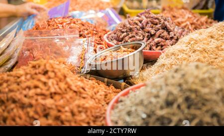 Ein Stallverkäufer, der trockenen Garnelenfisch und verschiedene Zutaten in einem beliebten Markt verkauft, wo viele traditionelle Lebensmittel gekauft werden können, in Taiwan. Kaufen Stockfoto