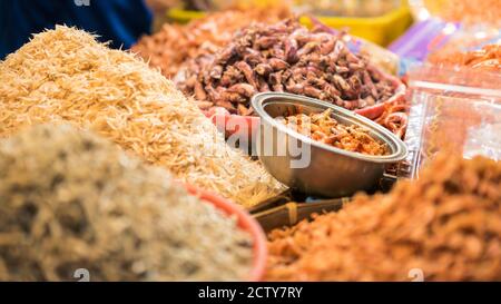 Ein Stallverkäufer, der trockenen Garnelenfisch und verschiedene Zutaten in einem beliebten Markt verkauft, wo viele traditionelle Lebensmittel gekauft werden können, in Taiwan. Kaufen Stockfoto