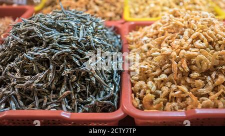 Ein Stallverkäufer, der trockenen Garnelenfisch und verschiedene Zutaten in einem beliebten Markt verkauft, wo viele traditionelle Lebensmittel gekauft werden können, in Taiwan. Kaufen Stockfoto