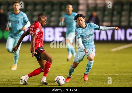 Lincoln City Verteidiger Timothy Eyoma (22) und Liverpool Vorwärts Takumi Minamino (18) während der englischen Liga-Cup, EFL Carabao Cup, Fußballspiel Wette Stockfoto