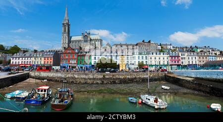 Fischerboote an einem Hafen mit einer Kathedrale im Hintergrund, St. Colman's Cathedral, Cobh, County Cork, Republik Irland Stockfoto