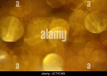 Glänzend abstrakter Hintergrund mit festlichen defokussierten Lichtern, leuchtend gelb Bokeh. Weihnachts- oder Neujahrsfest-Konzept. Stockfoto