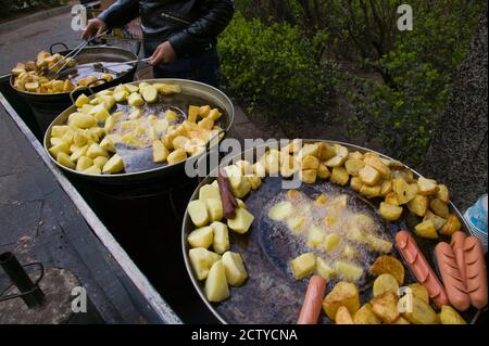 Verkäufer, der frittierte Kartoffeln und Würstchen an einem Imbissstand auf dem Bürgersteig, Altstadt, Dali, Provinz Yunnan, China verkauft Stockfoto