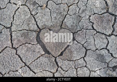 Trockene, rissige Erde mit einem herzförmigen Zentrum. Stockfoto