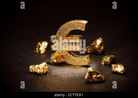 Gold Euro-Zeichen und Gold Nuggets auf schwarzem Hintergrund. Stockfoto