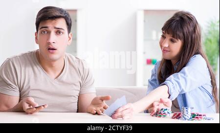 Die junge Familie, die Karten zu Hause Stockfoto