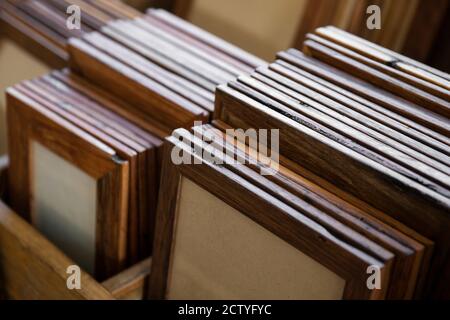 Eine Sammlung von handgefertigten Bilderrahmen aus Holz, die nach Größe und Art der Behandlung in Gruppen angeordnet sind. Stockfoto