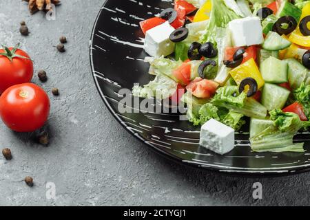 Griechischer Salat mit Cucumeber, Kalamata Oliven, Feta-Käse, saftigen Kirschtomaten und frischem Basilikum. Konzept für eine leckere und gesunde vegetarische Mahlzeit Stockfoto