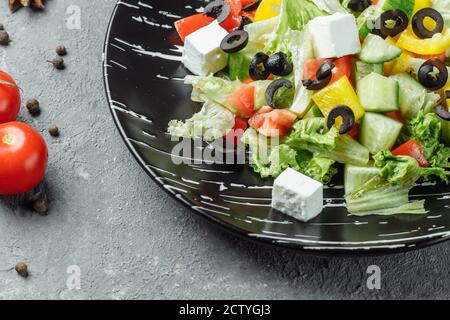 Griechischer Salat mit Cucumeber, Kalamata Oliven, Feta-Käse, saftigen Kirschtomaten und frischem Basilikum. Konzept für eine leckere und gesunde vegetarische Mahlzeit Stockfoto