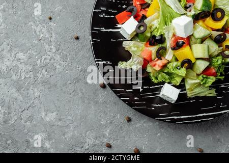 Griechischer Salat mit Cucumeber, Kalamata Oliven, Feta-Käse, saftigen Kirschtomaten und frischem Basilikum. Konzept für eine leckere und gesunde vegetarische Mahlzeit Stockfoto