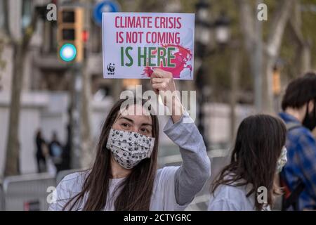 Barcelona, Spanien. September 2020. Ein Klimaaktivist mit einer Gesichtsmaske hält während der Demonstration ein Plakat, das vor dem bevorstehenden Klimawandel warnt.rund 300 Klimaaktivisten haben sich am Passeig de Gràcia in Barcelona versammelt, um den Globalen Tag der Klimapolitik zu feiern. Kredit: SOPA Images Limited/Alamy Live Nachrichten Stockfoto