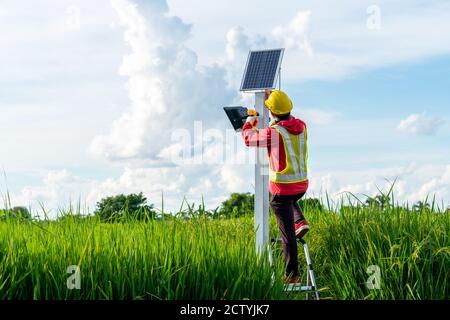 Asian Techniker installieren die Wartung der Sonnenkollektoren, Außenbeleuchtung Stange mit kleinen Solarpanel Strom von ihnen selbst ist neue Technologie und ENE Stockfoto