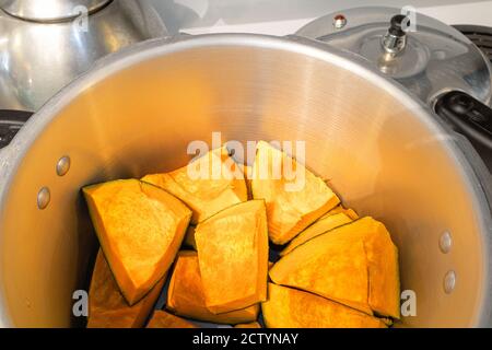 Buttercup-Squash-Stücke im Schnellkochtopf. Kabocha Squash, Turban Squash oder Cucurbita maxima. Orange süßes Fruchtfleisch, reich an Vitamin A und Ballaststoffen. Stockfoto