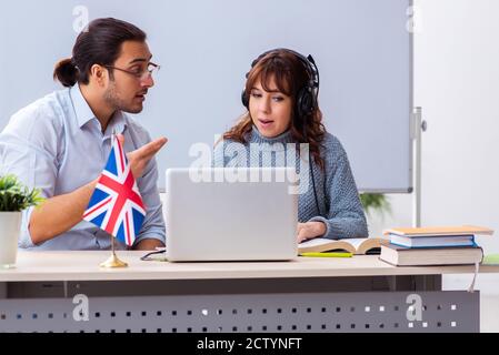 Junger Schüler und männlicher englischlehrer im Klassenzimmer Stockfoto
