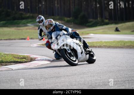 Motorrad Übung in einer schnellen Ecke auf der Strecke gelehnt. Stockfoto