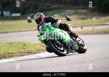 Motorrad Übung in einer schnellen Ecke auf der Strecke gelehnt. Stockfoto