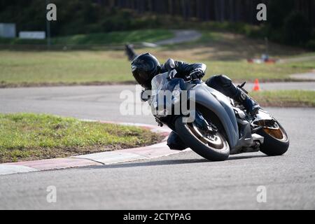 Motorrad Übung in einer schnellen Ecke auf der Strecke gelehnt. Stockfoto