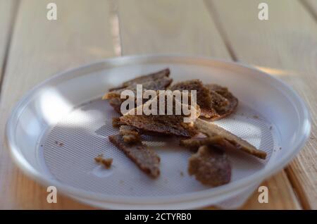 Roggencroutons in einem weißen Einwegteller. Nahaufnahme von delikaten, würzigen, salzigen Biersnacks. Selektiver Fokus. Stockfoto